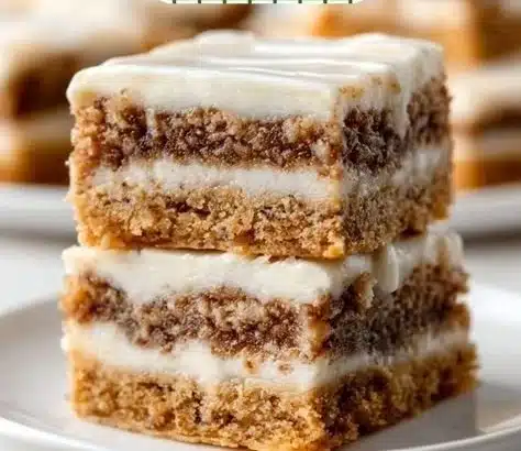 Delicious cinnamon roll bliss bars topped with icing on a white plate.