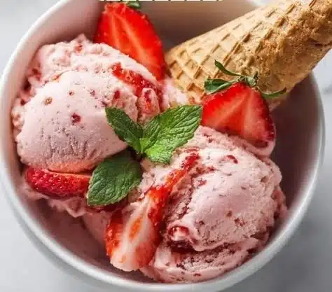 Delicious homemade strawberry ice cream in a bowl with fresh strawberries