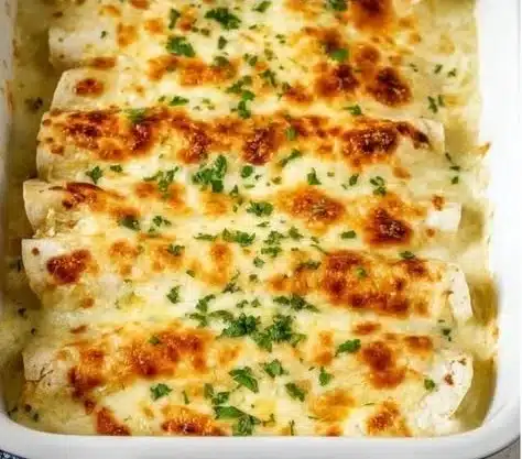 Creamy white chicken enchiladas topped with cheese and cilantro