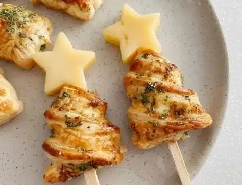 Ham and cheese puff pastry arranged as Christmas trees, perfect holiday appetizer.