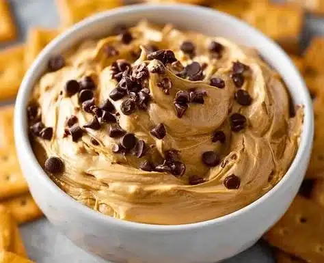 Creamy Buckeye Dip served in a bowl with pretzels and apple slices