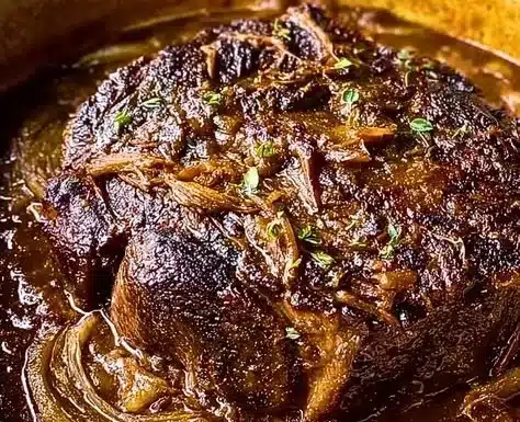 Delicious Caramelized French Onion Pot Roast served with herbs and vegetables.
