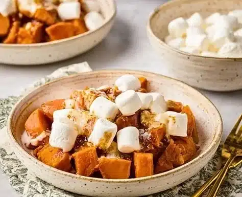 Crockpot sweet potatoes topped with marshmallows in a warm dish