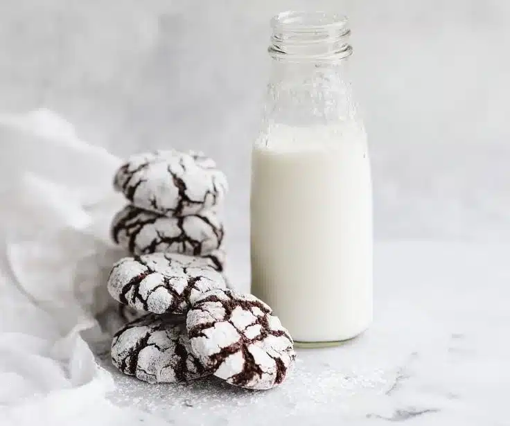 Gluten-free chocolate crinkle cookies on a baking sheet, fudgy and delicious.