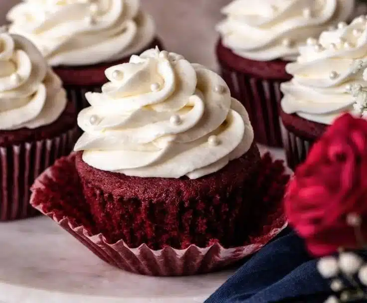 Delicious red velvet cupcakes with creamy frosting on a white plate